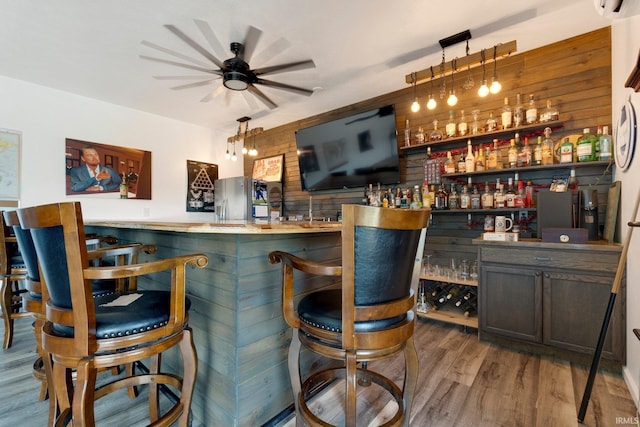3631 E Pierceton Rd, Warsaw, IN 46580 - indoor wet bar with stainless steel fridge with ice dispenser, wood finished floors, a ceiling fan, wood walls, and decorative light fixtures