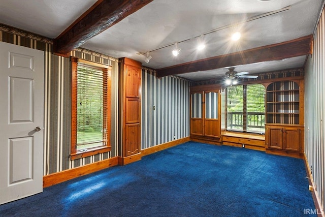 3911 Kings Ridge Rd, Mitchell, IN 47446 - empty room with dark colored carpet, a ceiling fan, rail lighting, and beamed ceiling