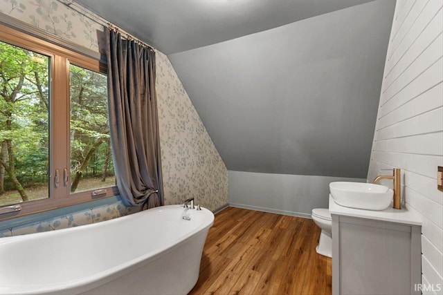 3911 Kings Ridge Rd, Mitchell, IN 47446 - full bathroom featuring a soaking tub, wood finished floors, lofted ceiling, vanity, and wallpapered walls