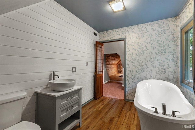 3911 Kings Ridge Rd, Mitchell, IN 47446 - bathroom with a soaking tub, wood finished floors, vanity, and wallpapered walls