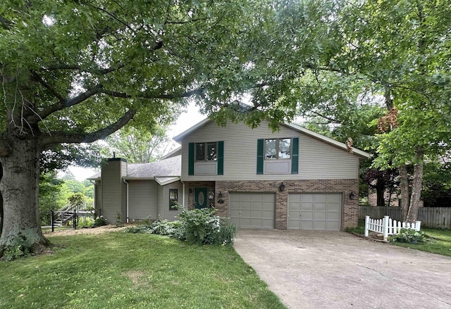 3108 E Charles Ct, Bloomington, IN 47401 - view of front of property featuring an attached garage, brick siding, concrete driveway, and a chimney