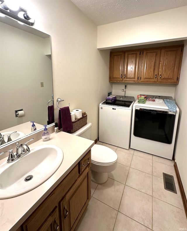 3108 E Charles Ct, Bloomington, IN 47401 - half bathroom with washing machine and dryer, tile patterned flooring, vanity, and a textured ceiling