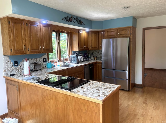 3108 E Charles Ct, Bloomington, IN 47401 - kitchen with freestanding refrigerator, dishwashing machine, light countertops, a peninsula, and decorative backsplash