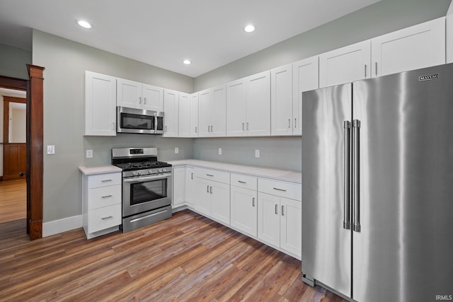 1028 Highland Ave, Lafayette, IN 47905 - kitchen featuring appliances with stainless steel finishes, light countertops, dark wood finished floors, white cabinetry, and recessed lighting