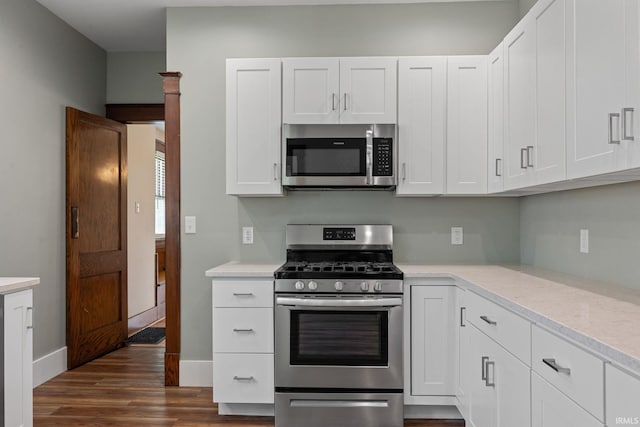 1028 Highland Ave, Lafayette, IN 47905 - kitchen with stainless steel appliances, light countertops, dark wood-style flooring, and white cabinets