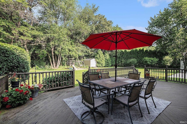 14341 Teal Ct, Granger, IN 46530 - wooden terrace featuring a storage shed, outdoor dining space, a yard, a playground, and view of wooded area