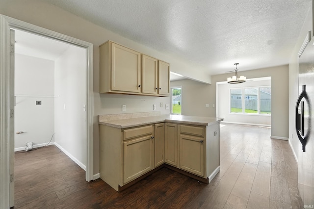 2005 Priscilla Ln, Kendallville, IN 46755 - kitchen featuring cream cabinetry, a peninsula, light countertops, dark wood-type flooring, and a chandelier