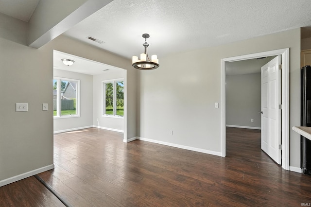 2005 Priscilla Ln, Kendallville, IN 46755 - empty room with a chandelier, dark wood-style floors, and a textured ceiling