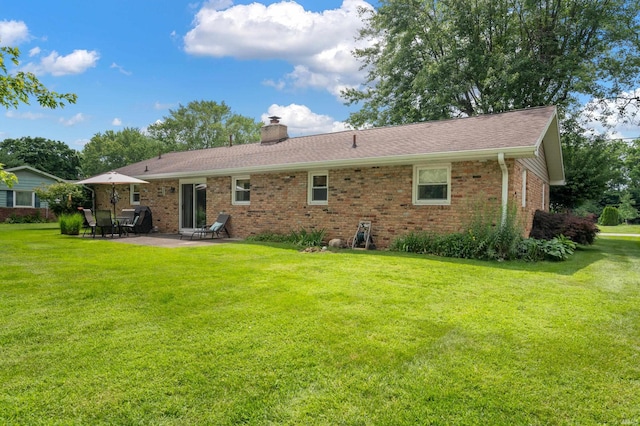 1308 N Buckeye Rd, Muncie, IN 47304 - back of property featuring a chimney, brick siding, a patio, and a yard