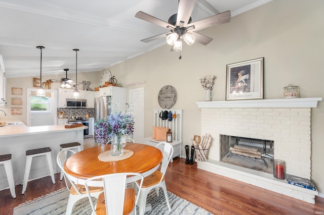 1308 N Buckeye Rd, Muncie, IN 47304 - dining area featuring ceiling fan, a brick fireplace, and wood finished floors