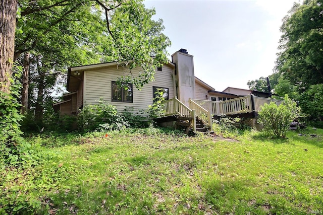 8426 Creekside Pl, Fort Wayne, IN 46804 - back of house featuring a chimney, a deck, and a lawn