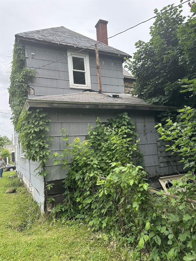 1127 S Jefferson St, Muncie, IN 47302 - view of side of property featuring a chimney and roof with shingles