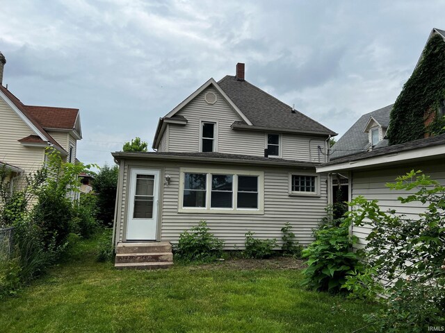 1026 E Wayne St, South Bend, IN 46617 - rear view of property featuring entry steps, a chimney, and a lawn