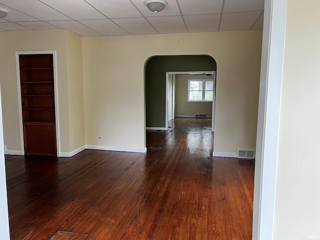 1026 E Wayne St, South Bend, IN 46617 - unfurnished room with arched walkways, built in features, dark wood-style flooring, and a paneled ceiling