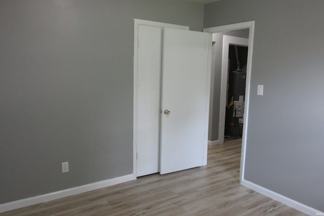907 S Tennessee, Muncie, IN 47302 - unfurnished bedroom with light wood-style floors and water heater
