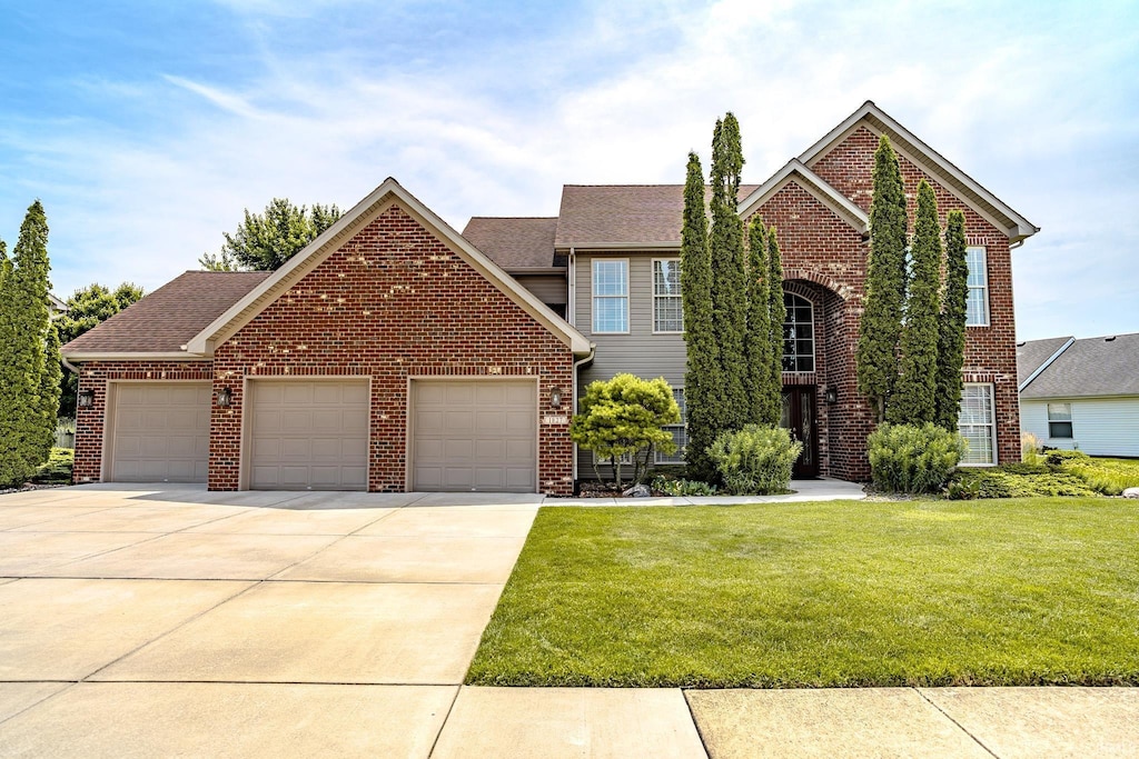 1827 Alydar Dr, West Lafayette, IN 47906 - view of front facade with brick siding, an attached garage, a front yard, and driveway