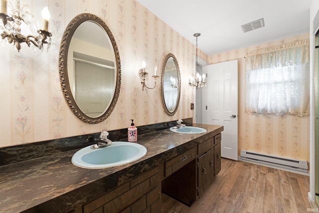 16801 Darling Rd, Woodburn, IN 46797 - bathroom with a baseboard heating unit, wallpapered walls, wood finished floors, and double vanity