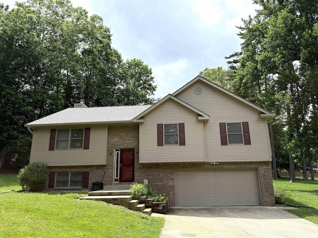 5918 S Foxwood Ln, Bloomington, IN 47401 - bi-level home with a garage, brick siding, driveway, a front lawn, and a chimney