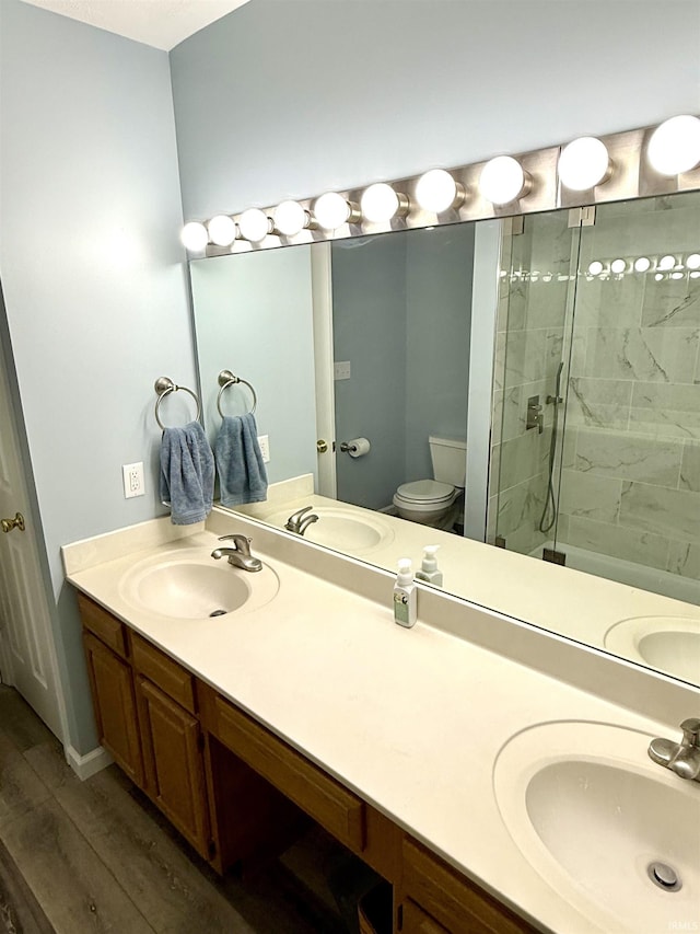 5918 S Foxwood Ln, Bloomington, IN 47401 - bathroom featuring double vanity, a stall shower, and wood finished floors
