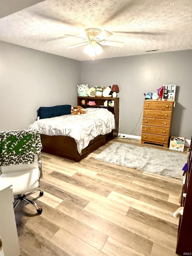 5918 S Foxwood Ln, Bloomington, IN 47401 - bedroom with wood finished floors, a textured ceiling, and a ceiling fan