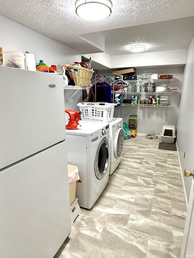 5918 S Foxwood Ln, Bloomington, IN 47401 - laundry room featuring washing machine and clothes dryer and a textured ceiling