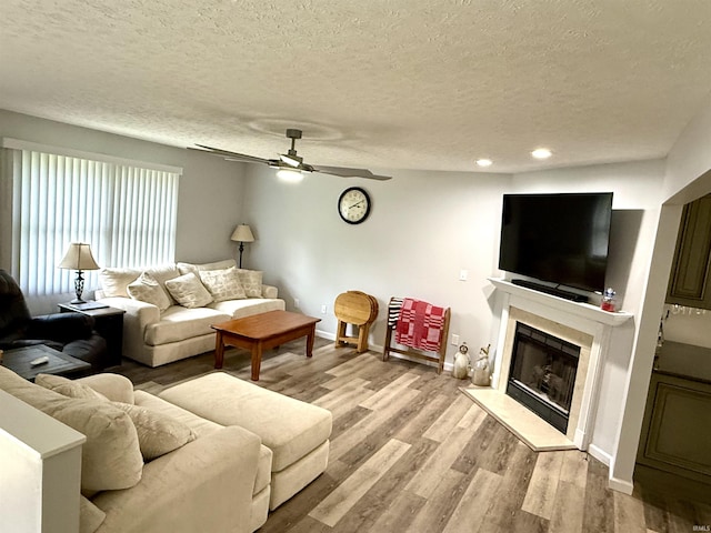 5918 S Foxwood Ln, Bloomington, IN 47401 - living area with a textured ceiling, ceiling fan, wood finished floors, a fireplace with raised hearth, and recessed lighting