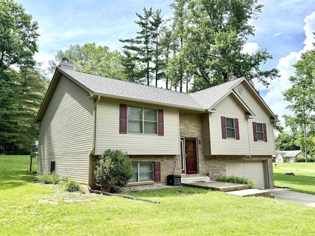 5918 S Foxwood Ln, Bloomington, IN 47401 - bi-level home featuring a chimney, asphalt driveway, a garage, a front lawn, and brick siding