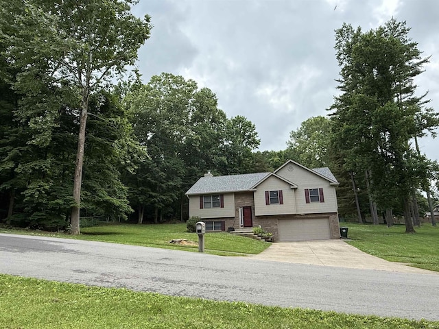 5918 S Foxwood Ln, Bloomington, IN 47401 - raised ranch with concrete driveway, a garage, brick siding, and a front lawn