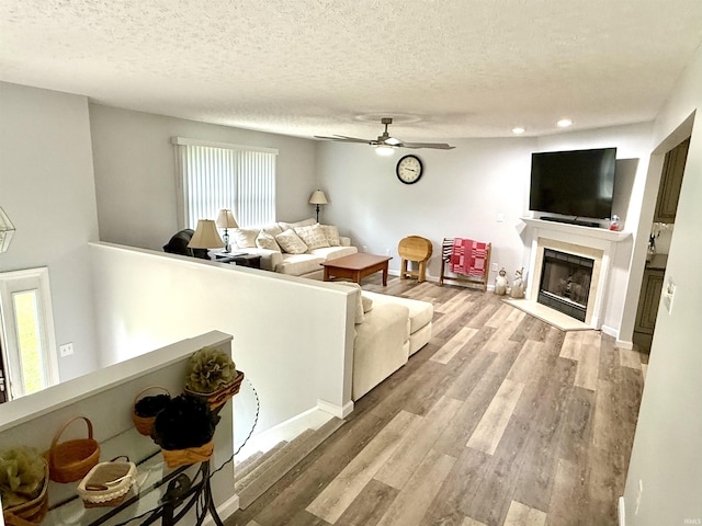 5918 S Foxwood Ln, Bloomington, IN 47401 - living area with wood finished floors, ceiling fan, a fireplace, a textured ceiling, and recessed lighting