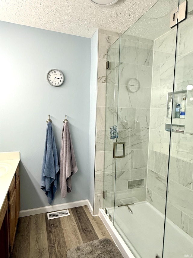 5918 S Foxwood Ln, Bloomington, IN 47401 - bathroom with wood finished floors, a stall shower, vanity, and a textured ceiling