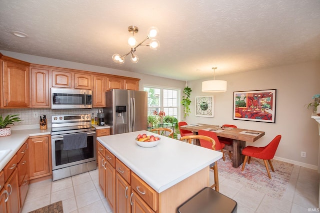 44 Fairfieldview Ct, Lafayette, IN 47905 - kitchen featuring appliances with stainless steel finishes, light countertops, light tile patterned floors, decorative backsplash, and a textured ceiling