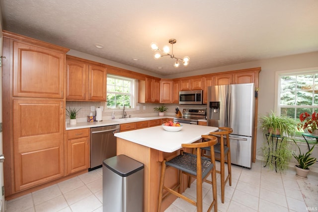 44 Fairfieldview Ct, Lafayette, IN 47905 - kitchen featuring appliances with stainless steel finishes, a chandelier, light tile patterned floors, and a center island