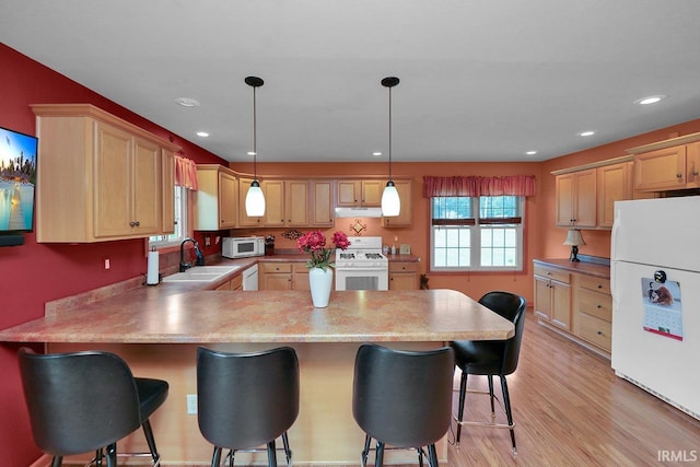 29876 County Road 18th Rd, Elkhart, IN 46517 - kitchen with white appliances, a peninsula, under cabinet range hood, a breakfast bar, and light wood finished floors