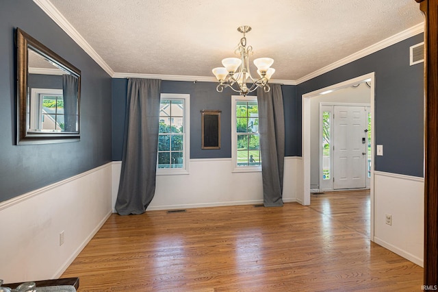 53135 W Cedar Lake Dr, Granger, IN 46530 - unfurnished dining area featuring a textured ceiling, a chandelier, wood finished floors, ornamental molding, and wainscoting