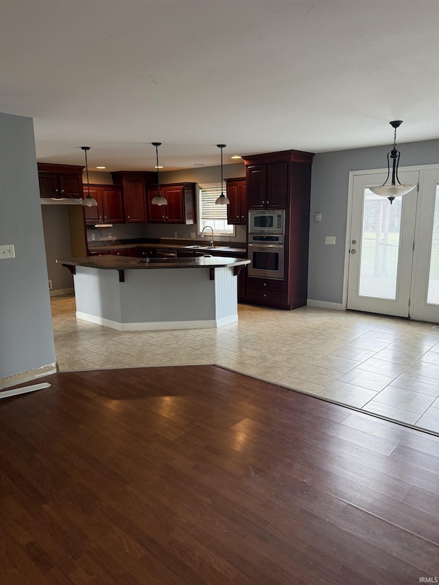 5450 Fox Chase Ct, Boonville, IN 47601 - kitchen featuring appliances with stainless steel finishes, dark countertops, reddish brown cabinets, and light wood-style flooring