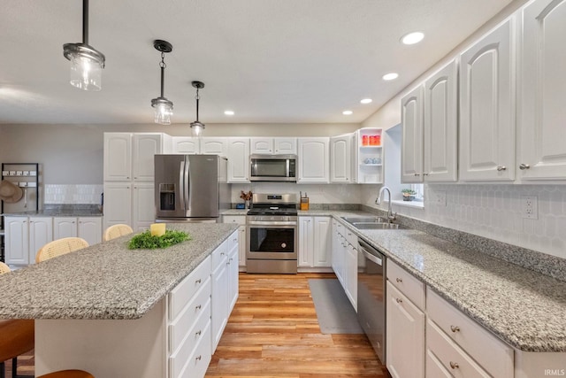 2770 N Baers Ct, Monticello, IN 47960 - kitchen with stainless steel appliances, light wood-style flooring, a kitchen island, white cabinets, and recessed lighting