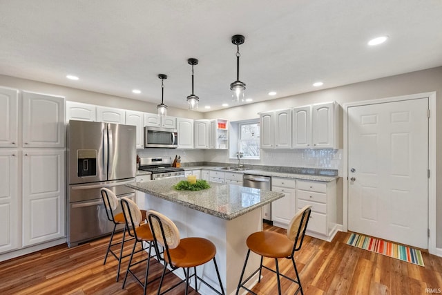 2770 N Baers Ct, Monticello, IN 47960 - kitchen featuring stainless steel appliances, a breakfast bar, white cabinetry, light wood-style floors, and recessed lighting