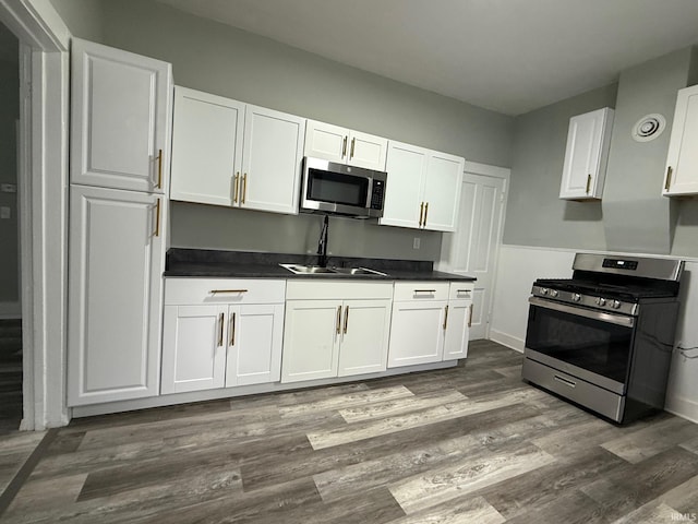1409 Oakland St, Fort Wayne, IN 46808 - kitchen featuring stainless steel appliances, white cabinets, dark countertops, and dark wood-style floors