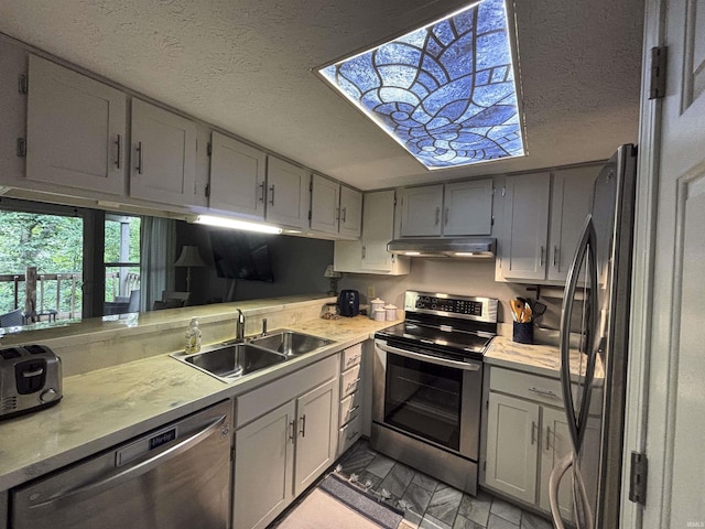 9324 S Lake Ridge Dr Unit 60, Bloomington, IN 47401 - kitchen with stainless steel appliances, under cabinet range hood, light countertops, gray cabinetry, and a textured ceiling