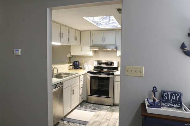 9324 S Lake Ridge Dr Unit 60, Bloomington, IN 47401 - kitchen with stainless steel appliances, under cabinet range hood, light countertops, and light marble finish floors