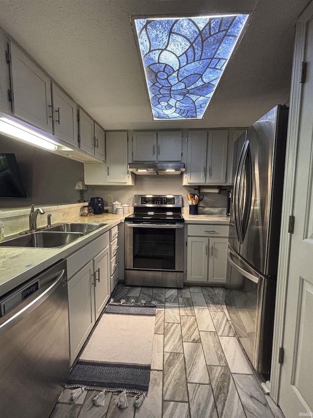9324 S Lake Ridge Dr Unit 60, Bloomington, IN 47401 - kitchen with appliances with stainless steel finishes, under cabinet range hood, gray cabinets, and light countertops