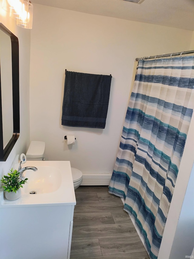 607 W 4th St, North Manchester, IN 46962 - full bathroom with a baseboard radiator, vanity, wood finished floors, and a shower with shower curtain