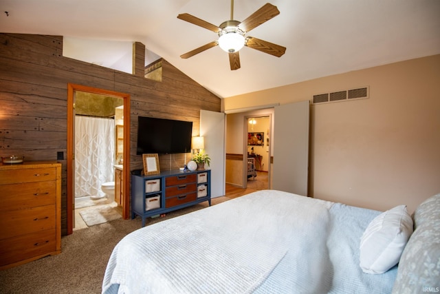 22885 Stonebrier Dr, Elkhart, IN 46514 - bedroom featuring wooden walls, lofted ceiling, carpet floors, ensuite bath, and ceiling fan