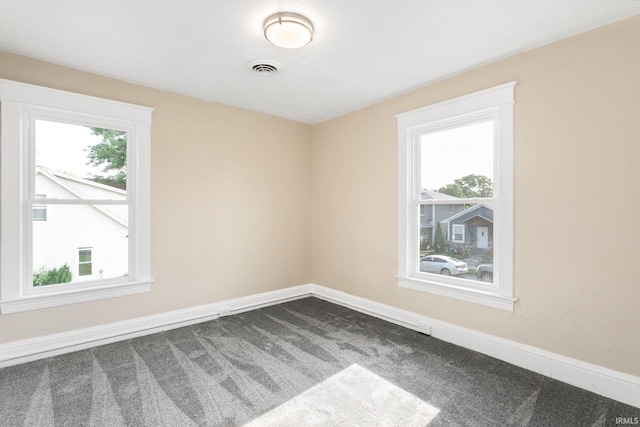 1009 N Adams St, South Bend, IN 46628 - spare room with dark colored carpet and baseboards
