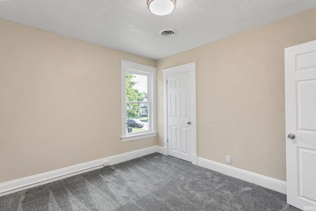 1009 N Adams St, South Bend, IN 46628 - unfurnished bedroom featuring dark carpet and a textured ceiling