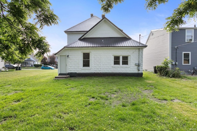 1009 N Adams St, South Bend, IN 46628 - rear view of house with a lawn and a metal roof