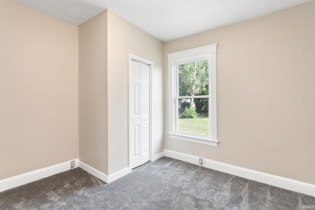 1009 N Adams St, South Bend, IN 46628 - spare room with dark carpet and baseboards