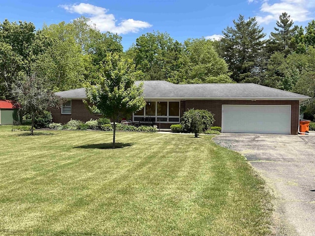 2127 Flora Dr, Peru, IN 46970 - ranch-style home featuring brick siding, a garage, asphalt driveway, and a front lawn