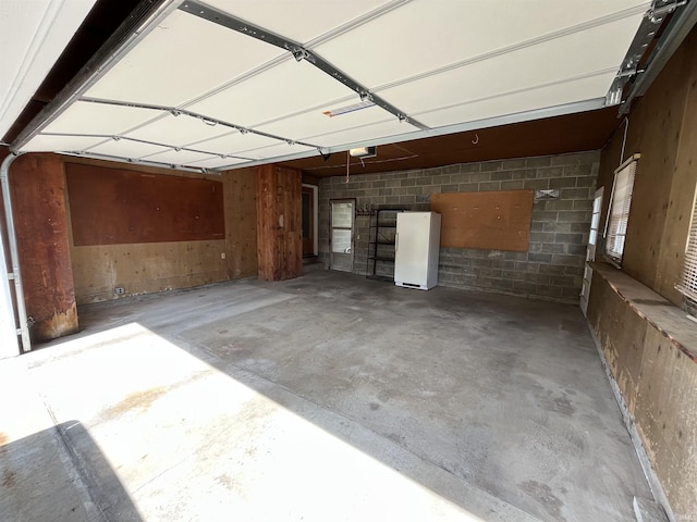 2127 Flora Dr, Peru, IN 46970 - garage with freestanding refrigerator and a garage door opener