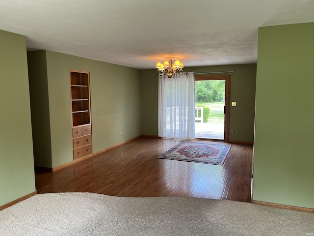 2127 Flora Dr, Peru, IN 46970 - spare room with a chandelier, wood finished floors, and built in shelves